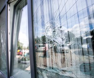 broken glass window of the modern building reflecting blue sky